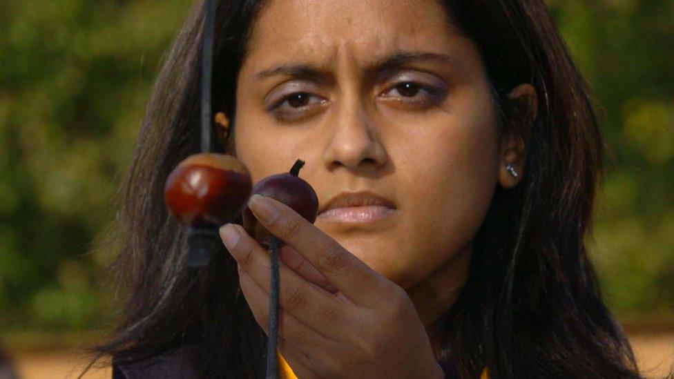 A woman prepared to strike her opponent's horse chestnut