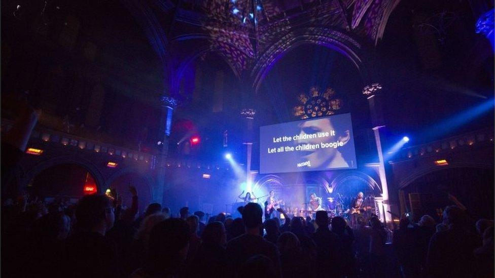 Fans stand and sing as a band plays during a tribute evening for British music legend David Bowie in London