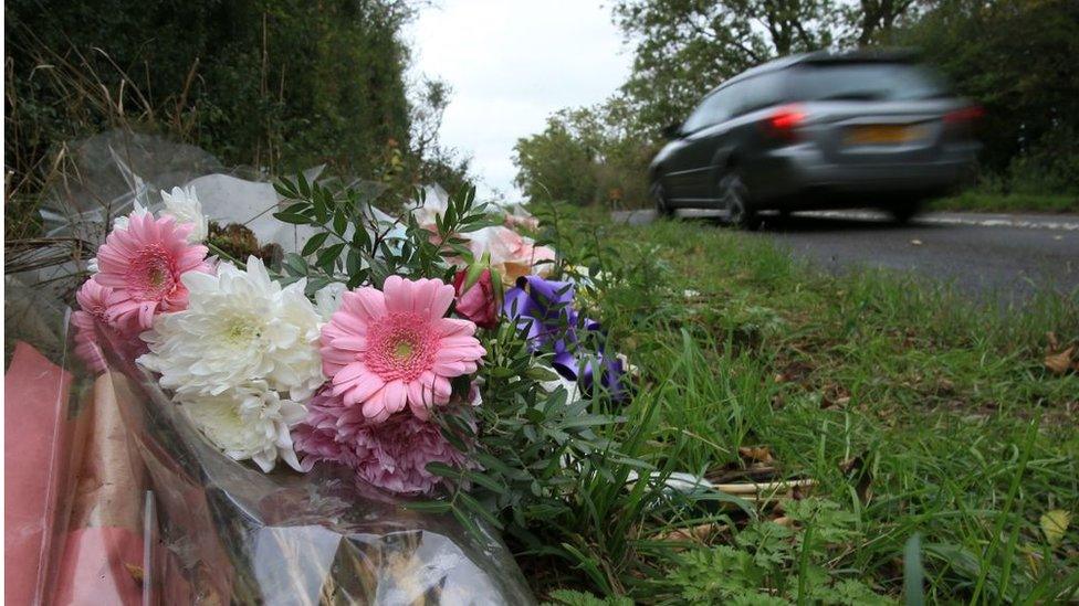 Floral tributes lay on the roadside near RAF Croughton in Northamptonshire, central England on October 10, 2019, at the spot where British motorcyclist Harry Dunn was killed