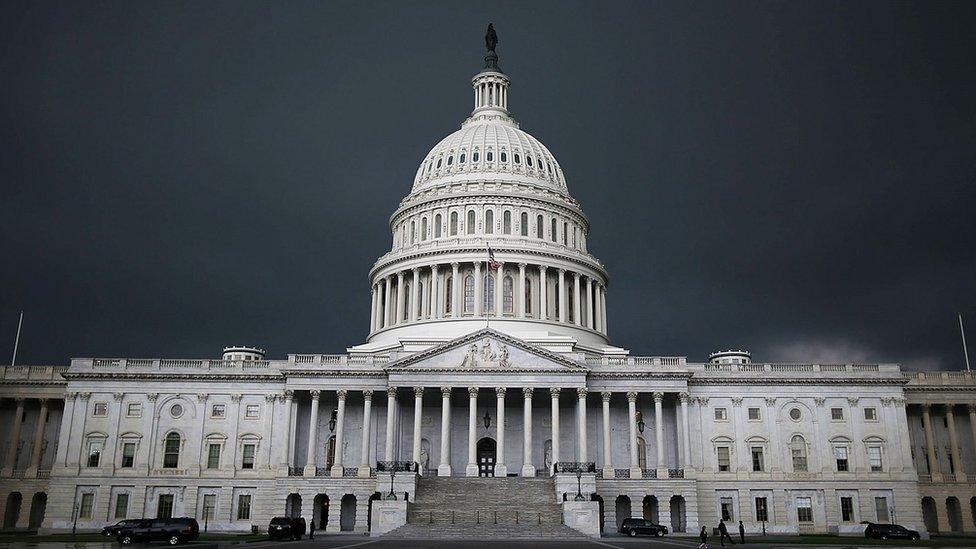 Storm clouds gather over US Capitol buidling.