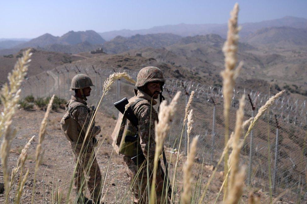 Pakistani soldiers keep vigil next to a newly fenced border fencing along Afghan border at Kitton Orchard Post in Pakistan's North Waziristan tribal agency on October 18, 2017.