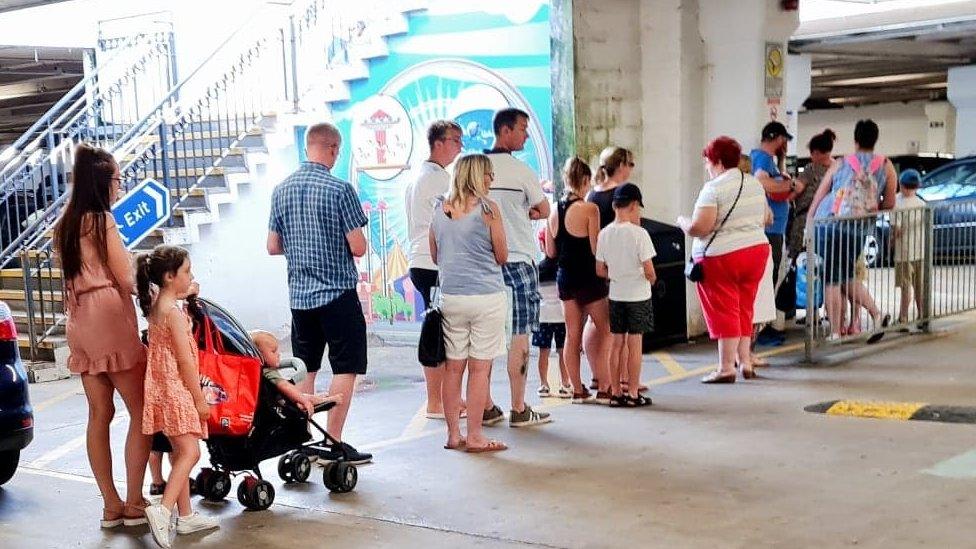 People queue at pay and display machine