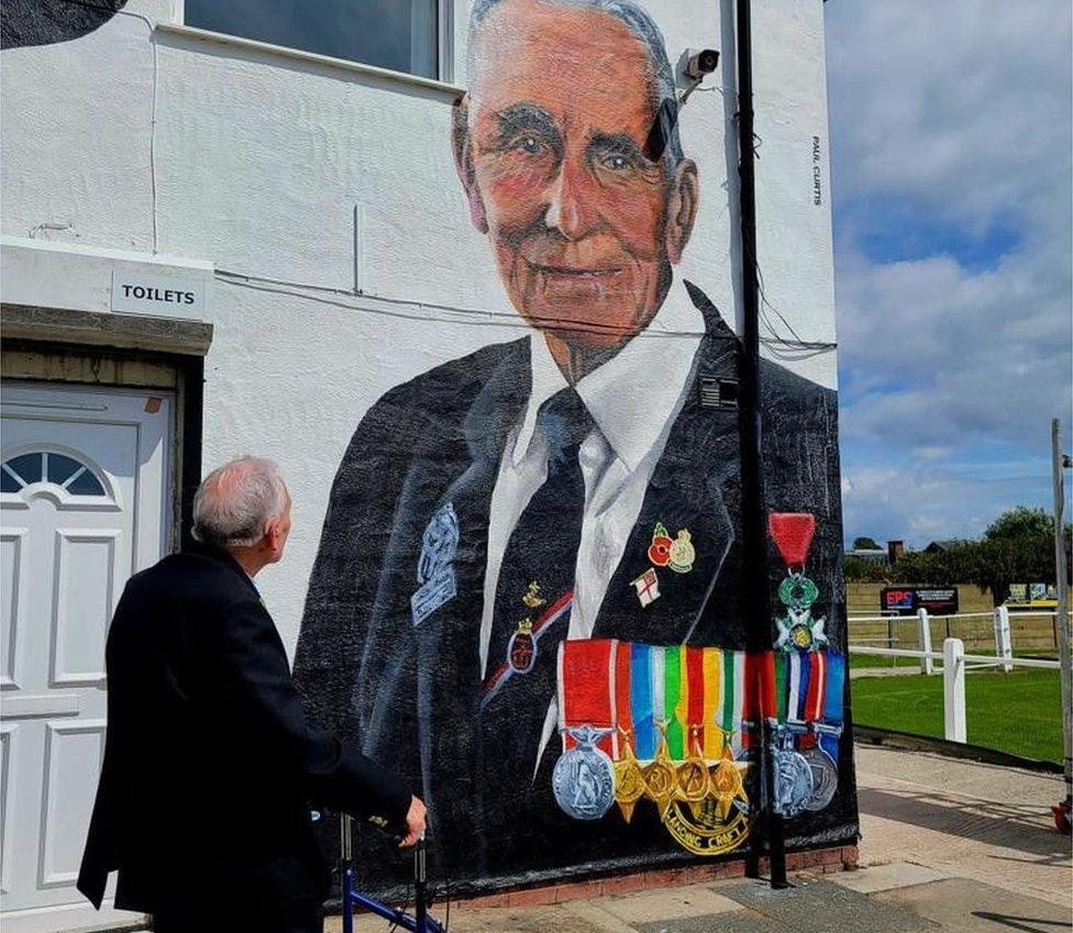 John Dennett admires the mural