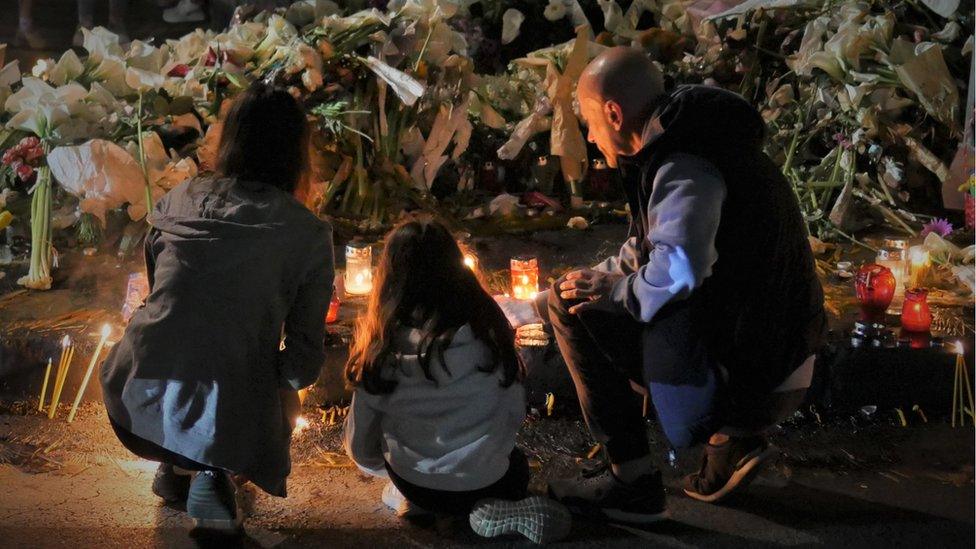 A man lays a tribute to the victims of a mass shooting at a school in Belgrade