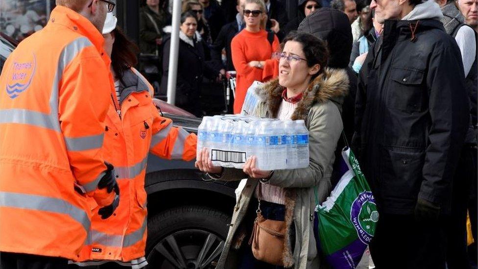 Local residents collect bottled water