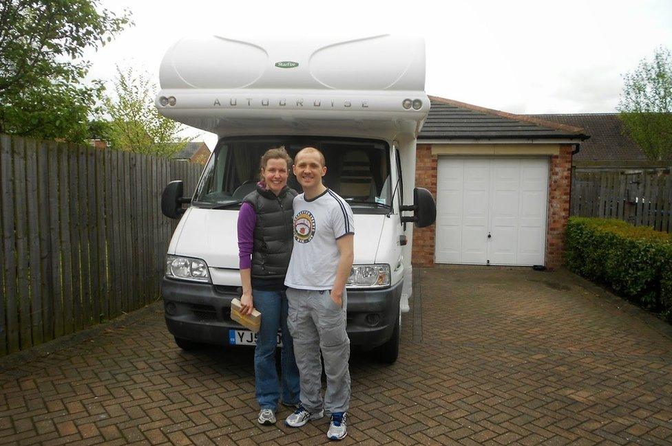 Dan and Esther stand in front of their campervan