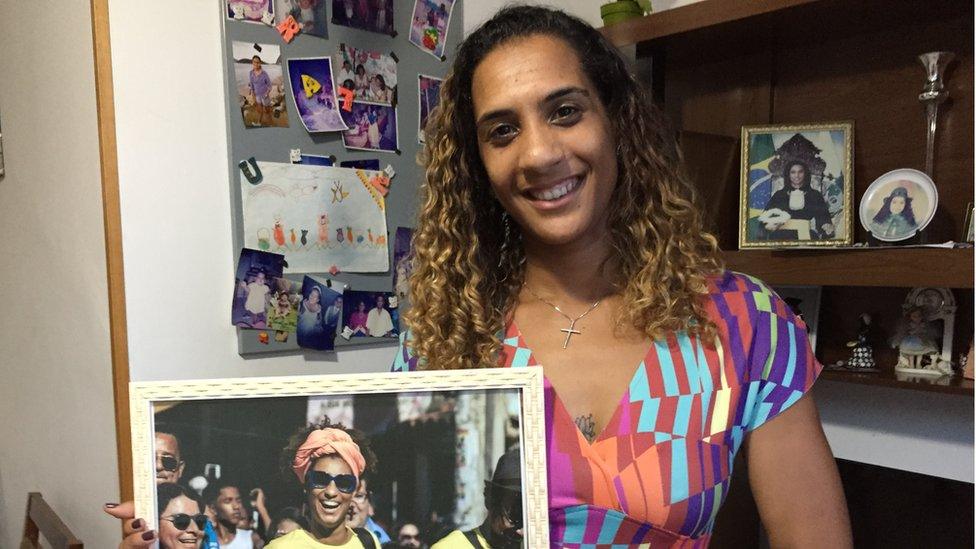 Anielle Silva holds up a photo of her sister Marielle Franco