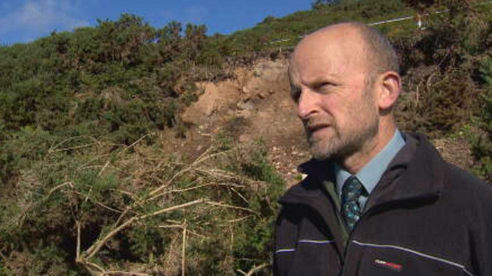 Councillor Matthew Reiss and the landslip in the background