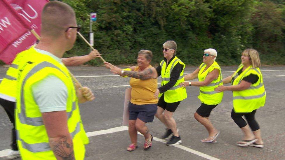 Survitec workers do the conga dance on the picket line outside the company's factory in Dunmurry