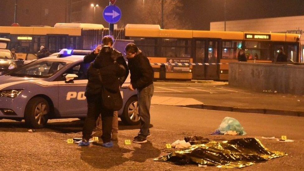 Italian Police officers work next to the body of Anis Amri, the suspect in the Berlin Christmas market truck attack, in a suburb of the northern Italian city of Milan, Italy December 23, 2016