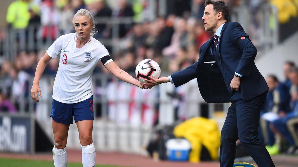 Phil Neville manager of England hands the ball to Alex Greenwood of England during a game