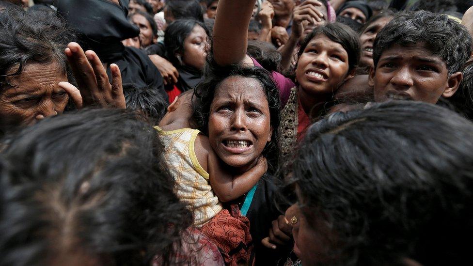 A woman reacts as Rohingya refugees wait to receive aid