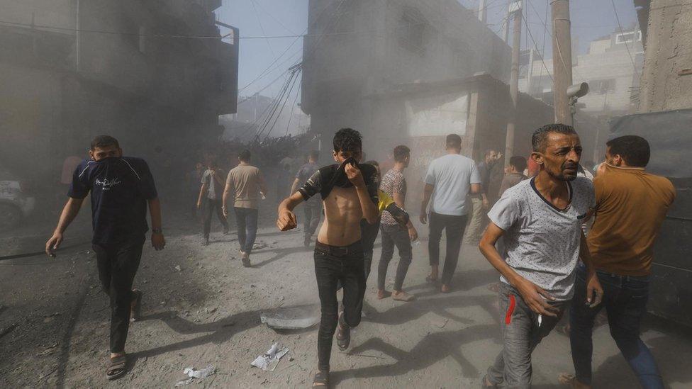 Palestinians react at the site of Israeli strikes on houses, as the conflict between Israel and Palestinian Islamist group Hamas continues, in Khan Younis in the southern Gaza Strip