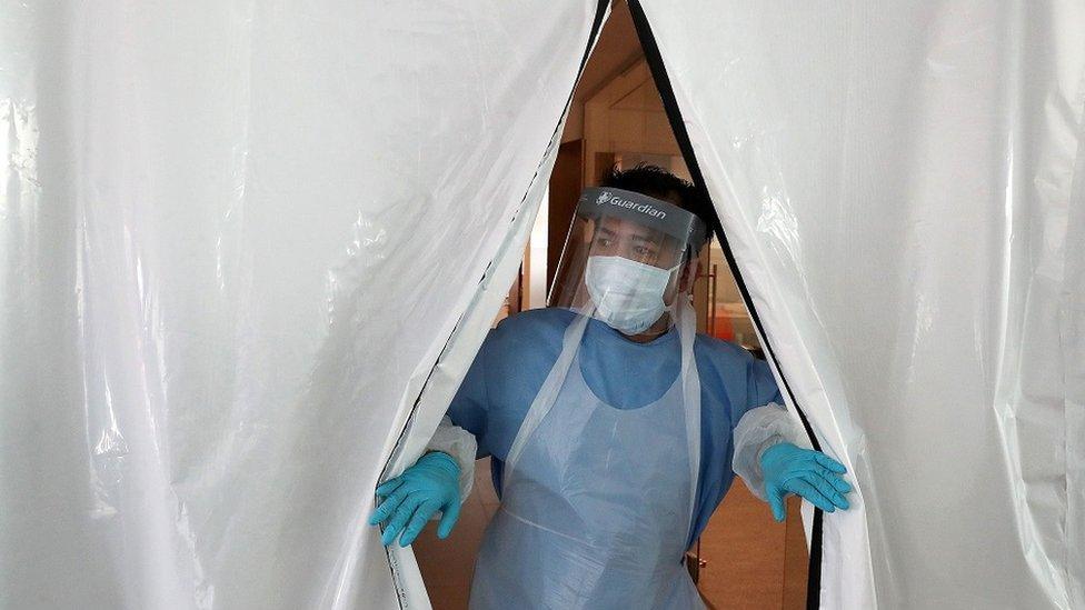 Technician in PPE at entrance to new laboratory