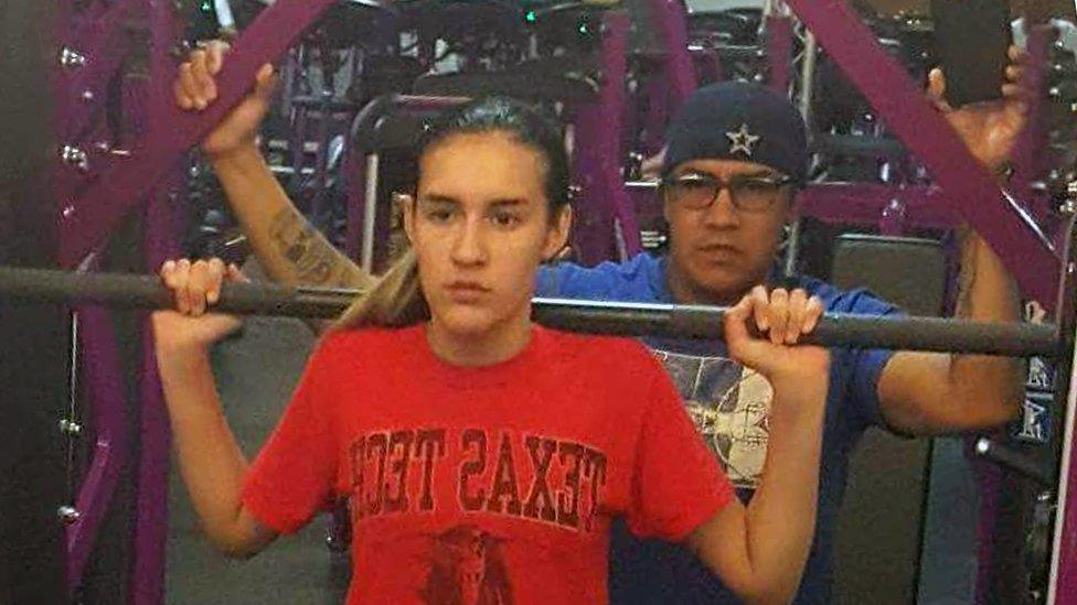 Adam helps his daughter Abby in the gym