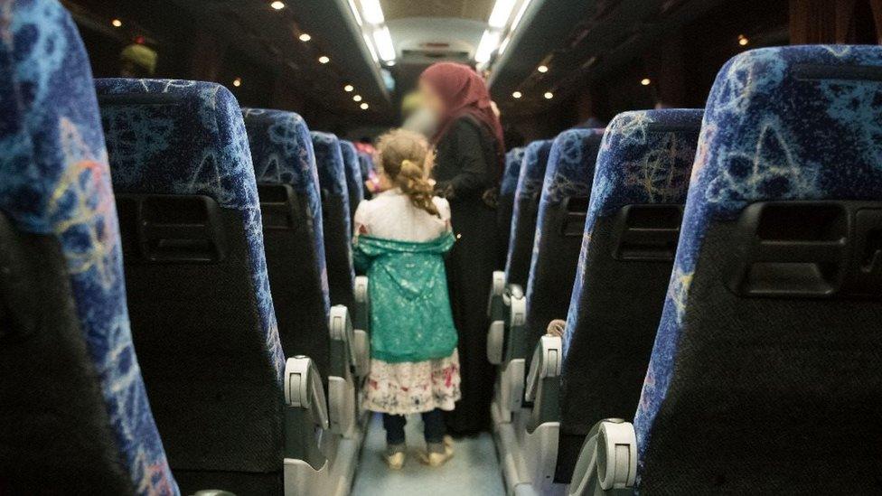 A woman and her child wait to get off the bus