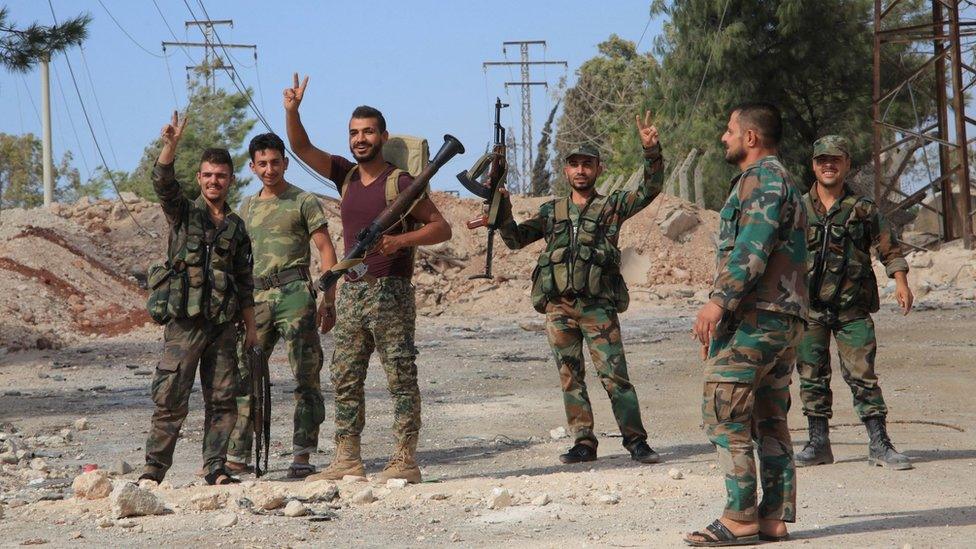 Syrian soldiers celebrate on 4 September 2016 in the southern outskirts of the Syrian city of Aleppo