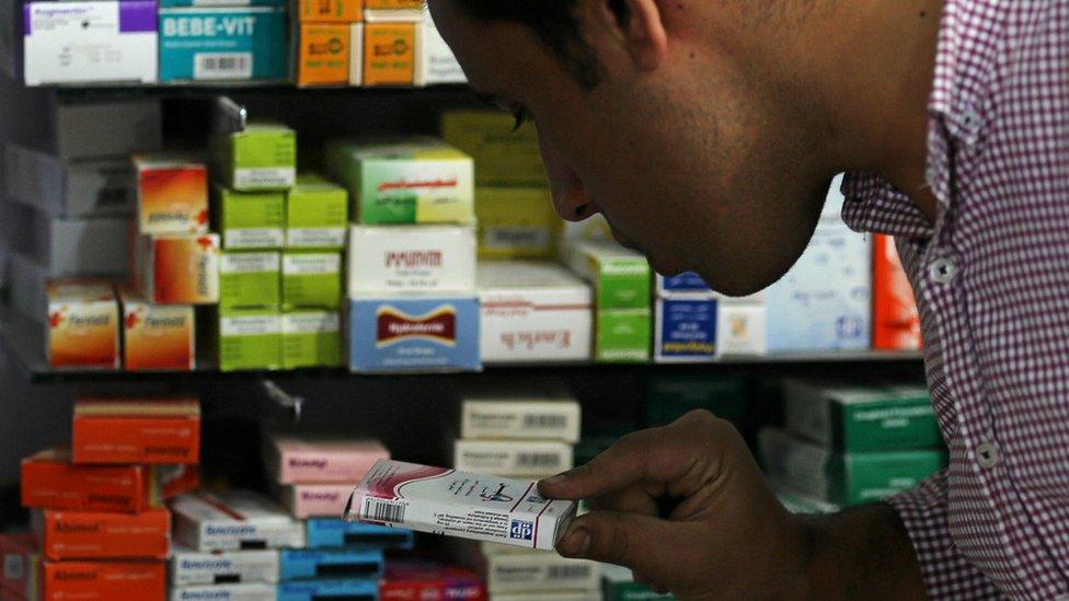 A man searches for the right medicine in a pharmacy