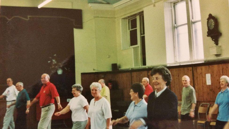 Harry in the back row of Rona's exercise class (wearing a red T-shirt)