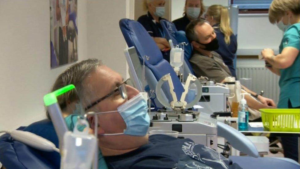 Patients sitting in a chair getting blood tests