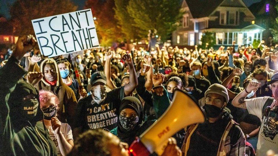 Protesters raise their fists during a demonstration after the release on bail of former police officer, Derek Chauvin, in Minneapolis, Minnesota, on October 7, 2020