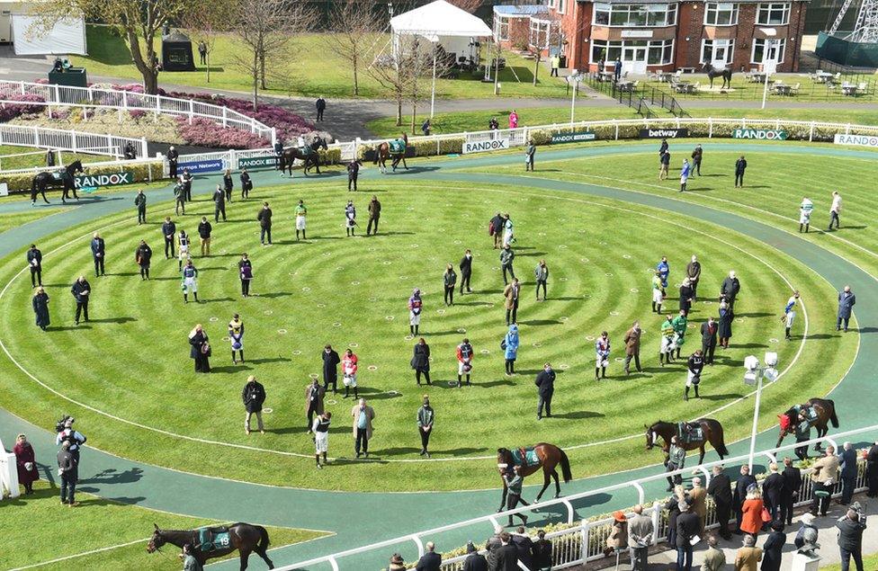 Jockeys and trainers observe two minutes of silence to honour the memory of Prince Philip at the racecourse in Aintree, Britain, 10 April 2021, before the start of the races on Grand National Day at the Grand National Festival in Aintree.