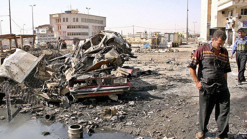 An Iraqi civilian inspects damage at a police station that was destroyed in a suicide car bomb attack in Mosul (26 June 2005)