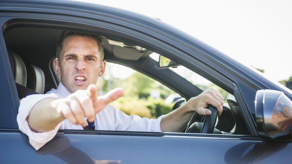 Stock image of a man shouting out of car window