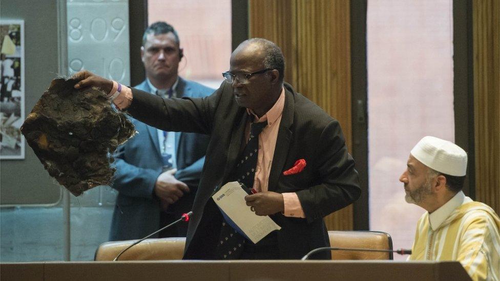 A local resident holds a piece of scorched material from Grenfell Tower at a meeting of Kensington and Chelsea council