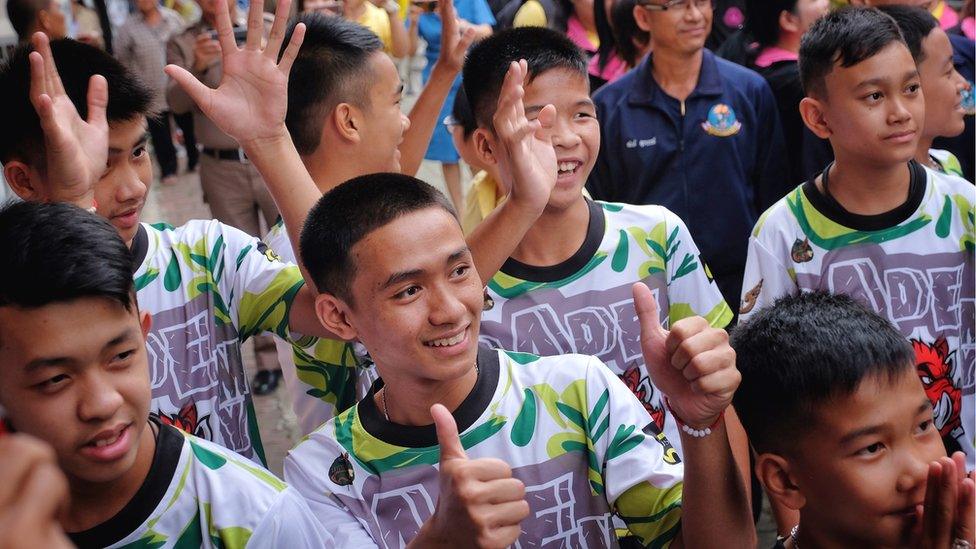 Twelve boys and their coach from the Wild Boars football team arrive for a press conference for the first time since they were rescued from a cave in northern Thailand last week, 18 July 2018