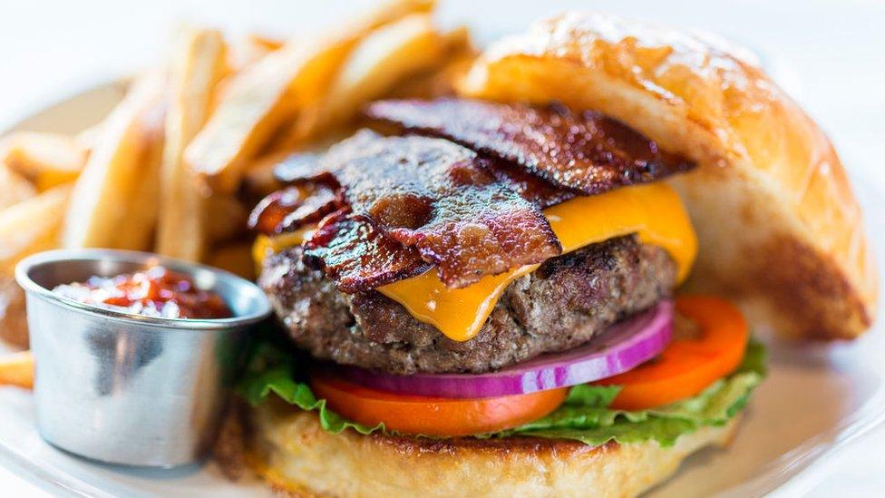 A bacon cheeseburger with fries