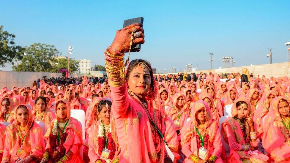 A Muslim bride takes a selfie with her mobile phone as she participates in an 'All Religion Mass Wedding' ceremony at Sabarmati Riverfront in Ahmedabad on February 8, 2020