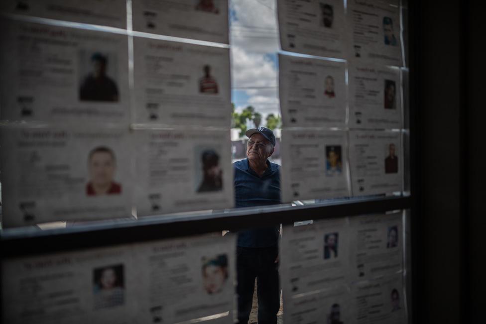 Don Pancho is seen looking through the notices of missing people