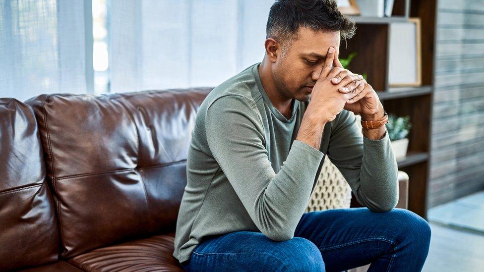 Man sitting worried on a sofa