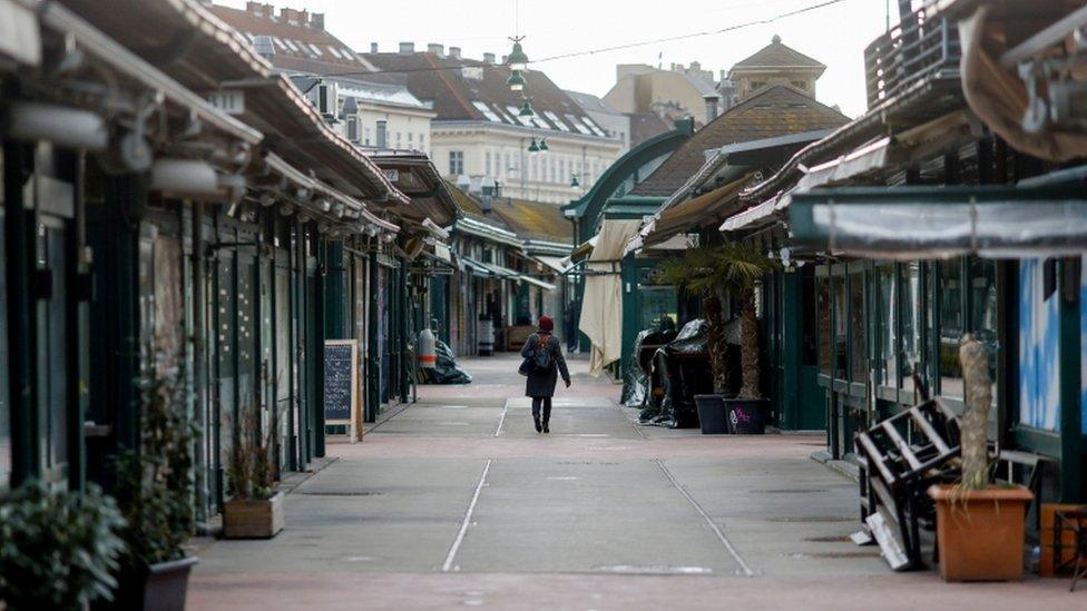 A lone person walks through a deserted street in the Austrian capital Vienna