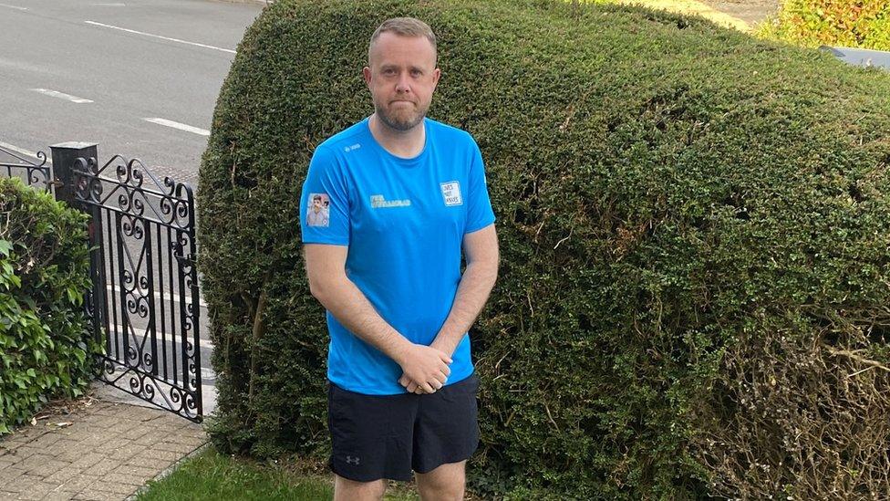 James Oakley in running gear standing in his garden