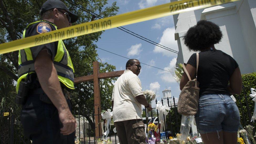 On Friday, people left flowers and messages of condolence behind police lines at Emanuel AME Church in Charleston, where nine people were murdered on Wednesday. 2015-06-19.