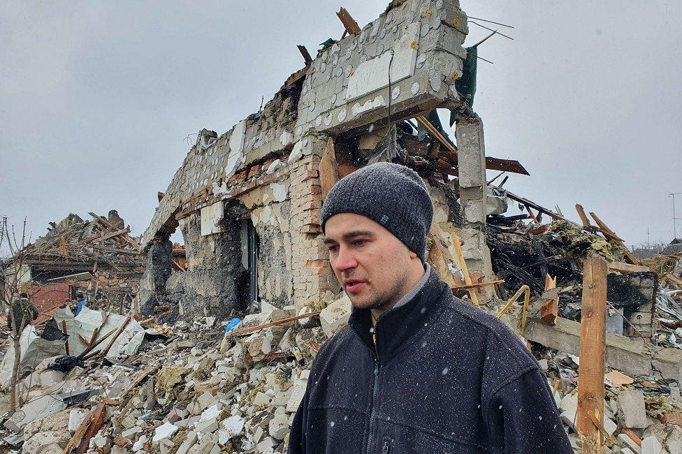 A man outside a destroyed building