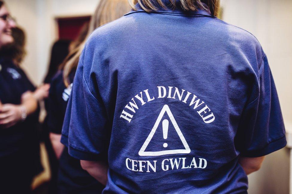 Crys T yn dweud 'Hwyl diniwed cefn gwlad'