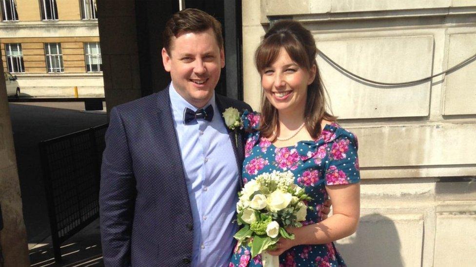 Katherine and Josh Varley holding a bouqet outside of the town hall