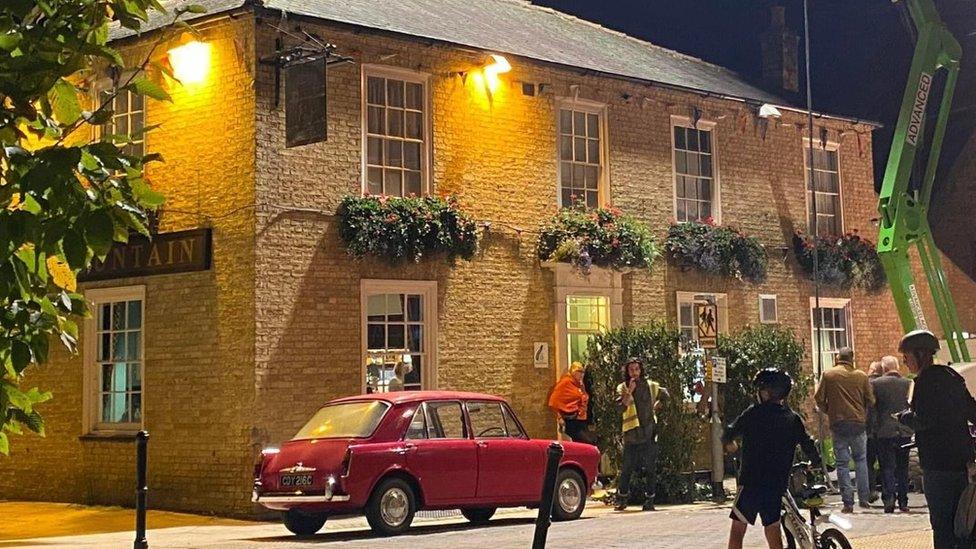 A pub, and old car and a crane