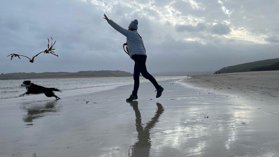 Woman with dog on beach in Padstow