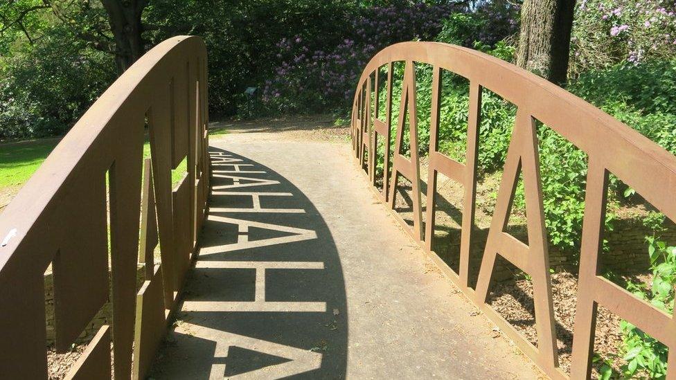 The words "Ha Ha" reflected by shadow on a bridge