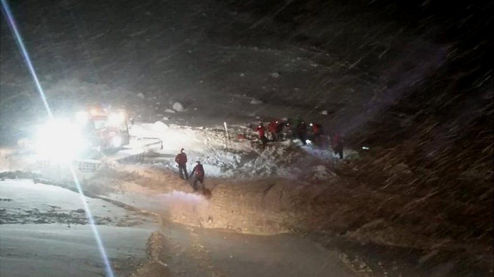 The Gröbming mountain rescue team work to free the skier