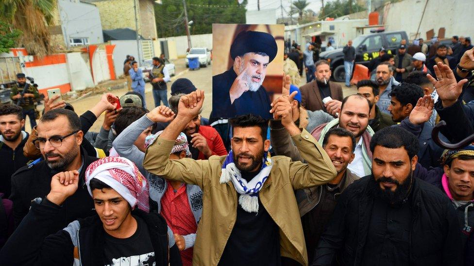 Supporter holds portrait of Moqtada al-Sadr, Najaf, Iraq (07/12/19)