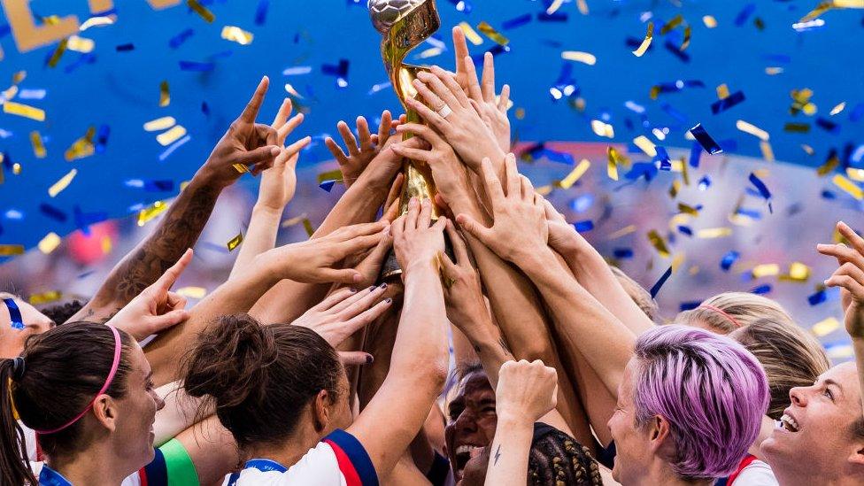 US women's football team holding trophy