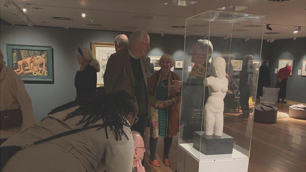 People looking at Torso - Woman sculpture, by Eric Gill