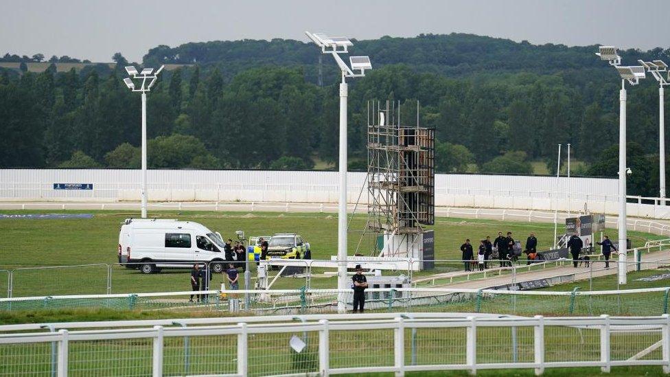 Police officers and other people on the track at a racecourse