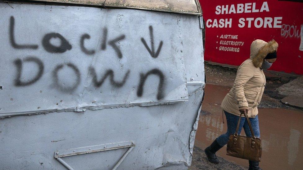 Woman walking past sign that says lock down