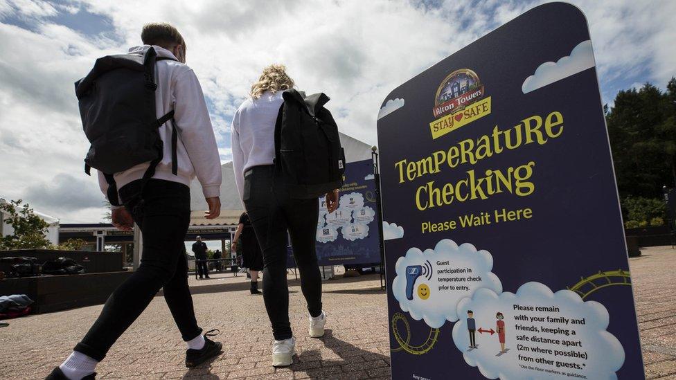 Visitors to Alton Towers walk past temperature testing